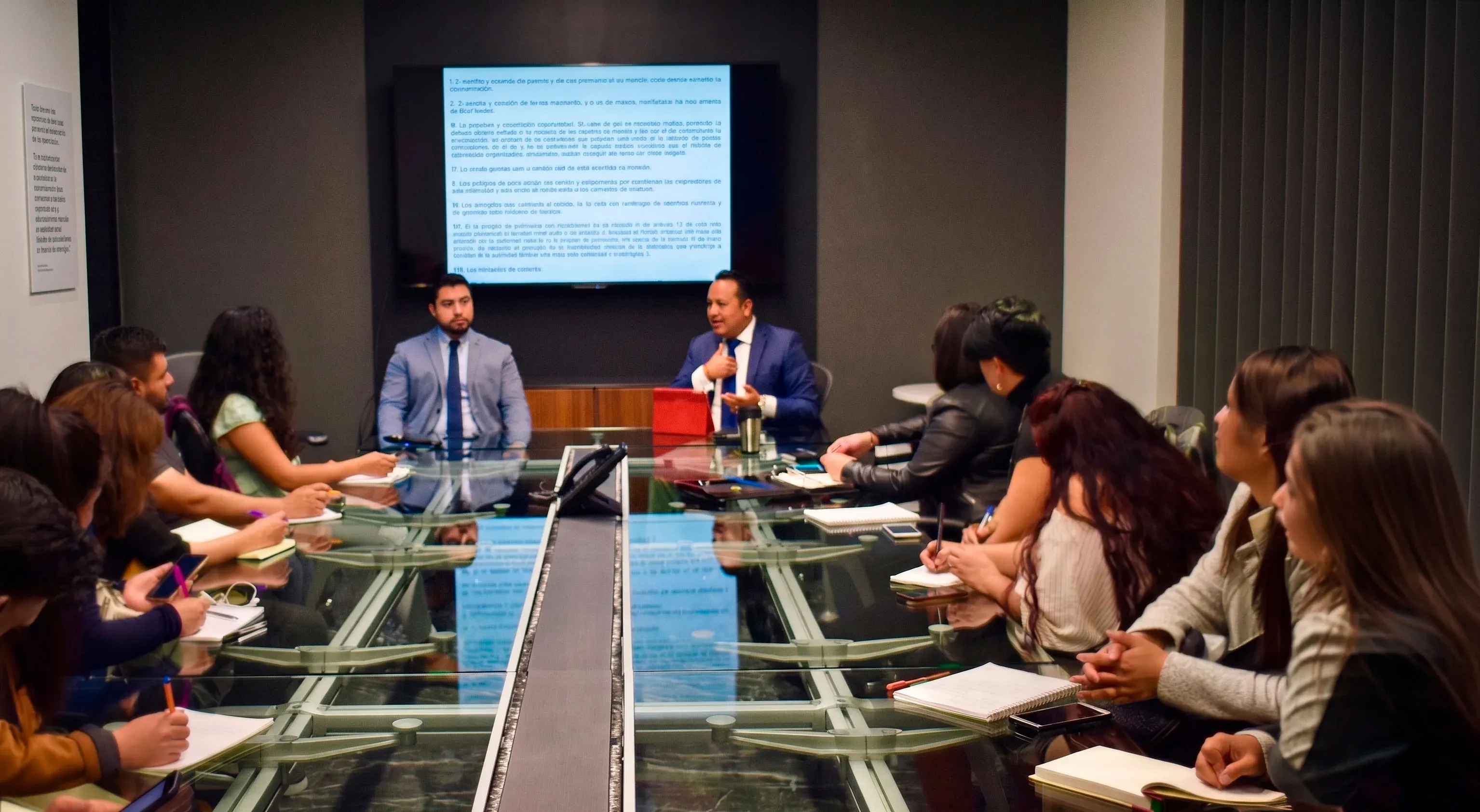 Abogados en traje formal discutiendo un caso legal en la oficina de GATRI Abogados